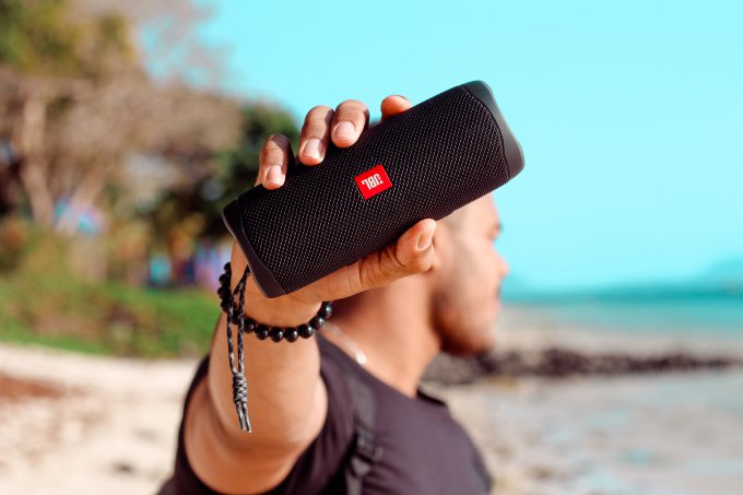Mężczyzna słucha muzyki używając głośnika Bluetooth